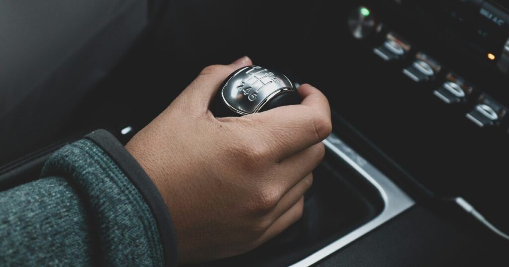 MT車のシフトノブを握って、ギアを操作している手