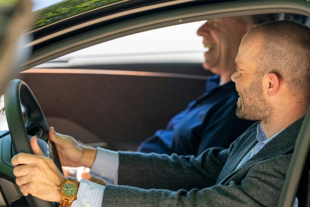 助手席に座って、運転する高齢の親の様子を見ている家族